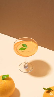 Şeftali kabartma masasında portakal meyvesi ve kokteyl bardağı olan yaratıcı kompozisyon. İkili ton arka planı. Asgari retro yaz tarzı.