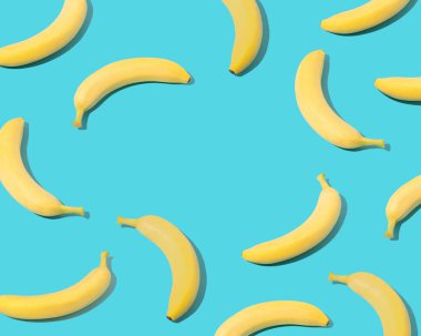 Trendy summer composition made of  yellow bananas on pastel blue background with copy space.