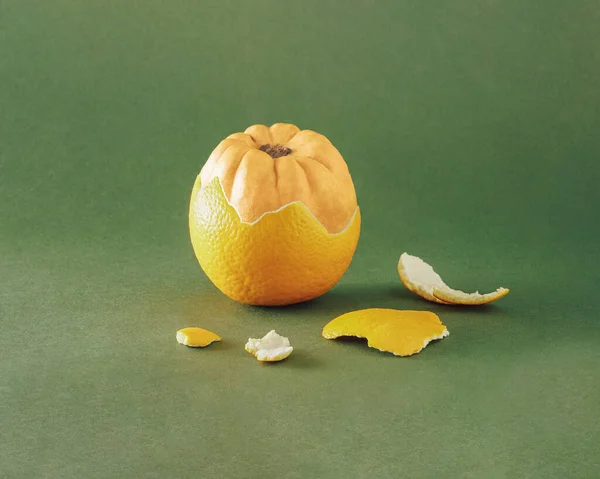 Kreatywny Skład Jesienną Dynią Wyskakującą Skórki Pomarańczy Zielonym Tle — Zdjęcie stockowe