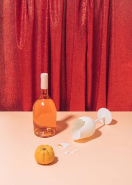 Bej masalı retrokompozisyon, parlak kırmızı perdeye karşı kırık şarap kadehi ve şişe. Klasik cadılar bayramı ya da Şükran Günü partisi konsepti.