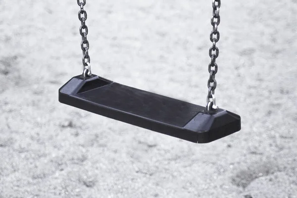 Wooden swing with metal chains for children. No people