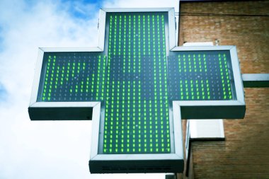 Yeşil eczane haçı 24 saat açık olduğunu gösteriyor. Kimse yok.