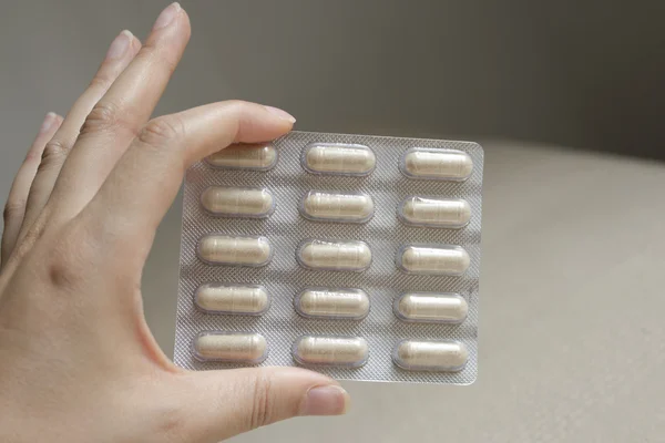 Mulher mão segurando lote de comprimidos — Fotografia de Stock