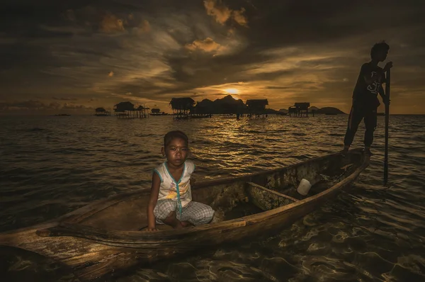 Remando o barco de madeira ao nascer do sol — Fotografia de Stock