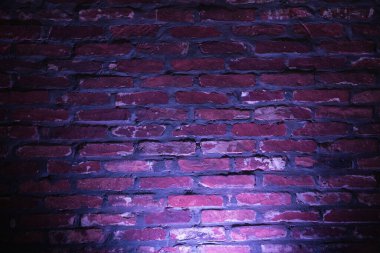 Arkaplan dokusu olarak açık mor neon ışıklı boş tuğla duvar.