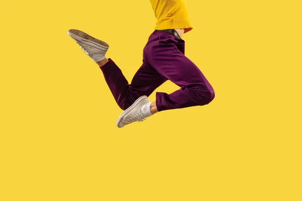 Νεαρός πηδάει απομονωμένος σε κίτρινο φόντο στούντιο — Φωτογραφία Αρχείου