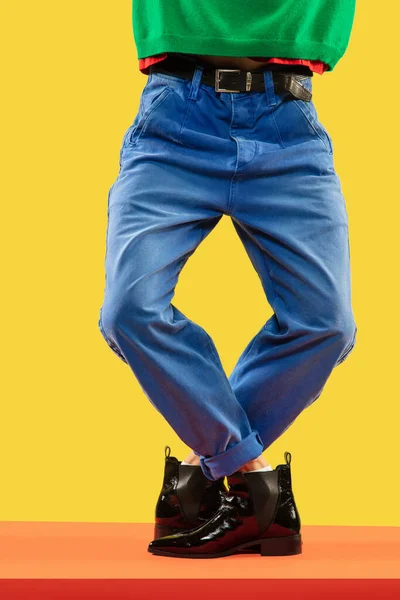 Unga herrben i blå jeans och svarta stövlar på rött golv — Stockfoto