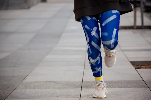 Junge Sportlerin in heller Sportkleidung beim morgendlichen Joggen im Freien. — Stockfoto