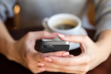 Yeni cep telefonu modelini tutan kadın eller.