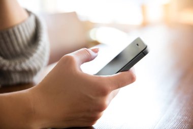 Akıllı telefonun yeni modelini tutan kadın eller.