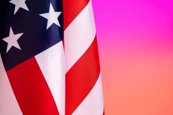 Närbild av amerikansk flagga på lutning rosa-persika färgad bakgrund i neon — Stockfoto