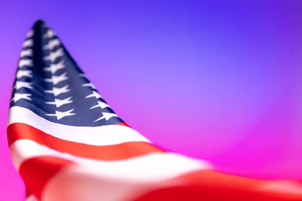 Nahaufnahme einer amerikanischen Flagge auf rosa-blauem Hintergrund im Neonlicht. — Stockfoto