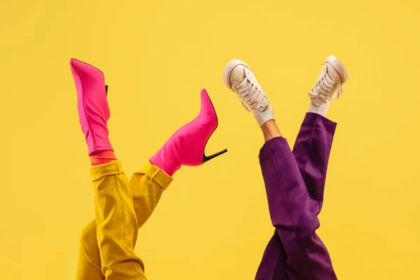 Moda modelli piedi in scarpe alla moda luminose isolato su sfondo giallo. — Foto Stock