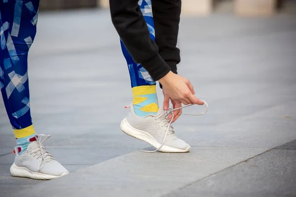 Corredor de fitness femenino atando cordones de zapatillas deportivas. Primer plano de las manos y las piernas. —  Fotos de Stock