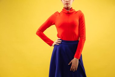 Sarı stüdyo arka planında izole edilmiş, gündelik giyinen genç bir kadın model.