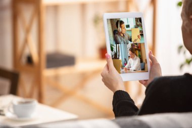 Genç bir bayanın arka görüntüsü kanepede oturup internette sohbet etmesi..