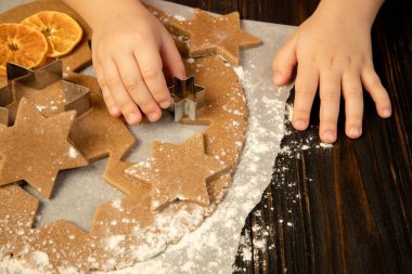 Çocuk elleri şenlikli dekorasyon ve ev yapımı zencefilli ekmek yapıyor..