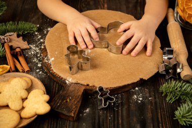 Çocuk elleri şenlikli dekorasyon ve ev yapımı zencefilli ekmek yapıyor..