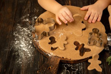 Çocuk elleri şenlikli dekorasyon ve ev yapımı zencefilli ekmek yapıyor..