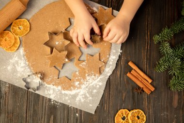 Çocuk elleri şenlikli dekorasyon, kurabiye ve ev yapımı zencefilli ekmek yapıyor..