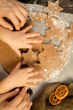 Yakın plan çocuk ve kadın elleri şenlikli kurabiyeler ve zencefilli kurabiye yapıyorlar..
