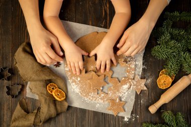 Yakın plan çocuk ve kadın elleri şenlikli kurabiyeler ve zencefilli kurabiye yapıyorlar..