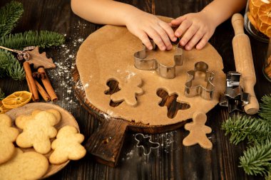 Küçük çocuk elleri zencefilli kurabiye ve şenlikli süslemeler yapıyor..