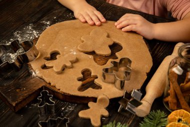 Küçük çocuk elleri zencefilli ekmek ve şenlikli kurabiyeler yapıyor. Tebrik kartı deisgn.