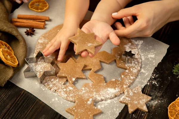 Yakın plan çocuk ve kadın elleri festival kurabiyeleri ve zencefilli kurabiye erkekler.