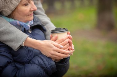 İki mutlu genç ve son sınıf öğrencisi dışarıda dinlenip kahve içiyorlar..