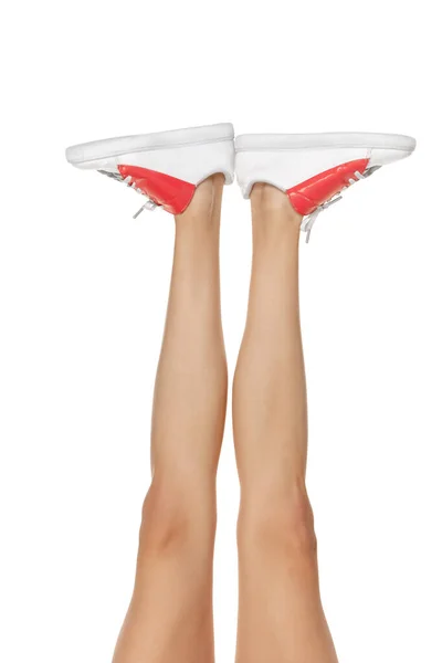 Close-up szczupłe kobiece nogi w białym obuwiu izolowane nad tłem studio — Zdjęcie stockowe