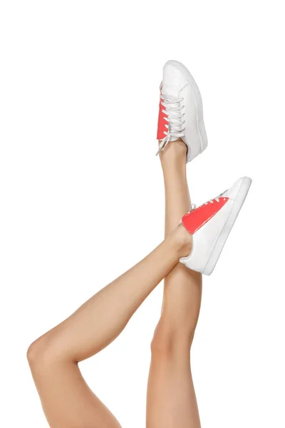 Close-up shapely female legs in white footwear isolated over studio background — Stock Photo, Image