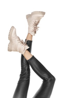 Beyaz arka planda izole edilmiş şık çizmeleri olan güzel, uzun ince kadın bacakları.