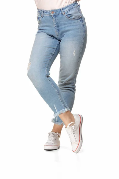 Vékony női lábak kék farmerban és sportcipőben elszigetelt fehér háttér — Stock Fotó