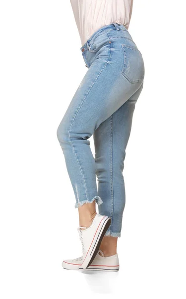 Piernas delgadas femeninas en jeans azules y zapatos deportivos aislados sobre fondo blanco —  Fotos de Stock