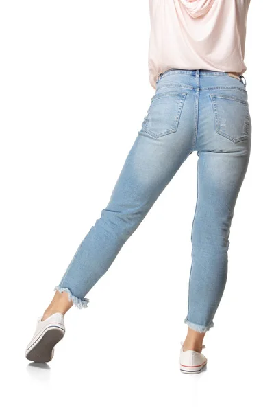 Visão traseira das pernas femininas em jeans azul e calçado isolado no fundo branco — Fotografia de Stock