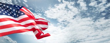 Arka planda güzel mavi bulutlu gökyüzü olan Amerikan bayrağı..