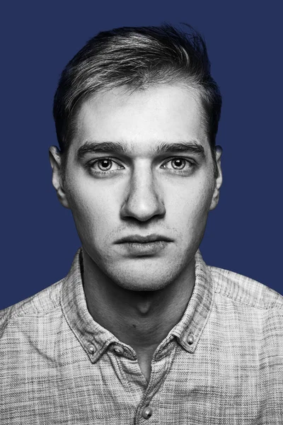Nahaufnahme Porträt eines hübschen jungen Mannes isoliert über blauem Hintergrund. — Stockfoto