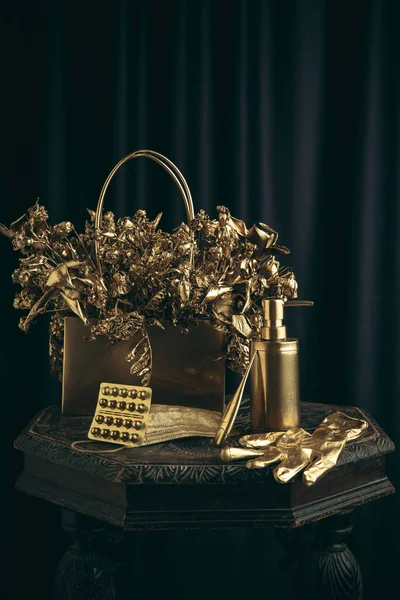 Ellerinde altın eldiven, yüz maskesi ve antiseptik olan modern klasik natürmort.