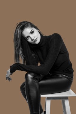 Kahverengi arka planda izole edilmiş güzel bir kızın siyah beyaz portresi..