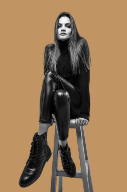 Kahverengi arka planda izole edilmiş güzel bir kızın siyah beyaz portresi..