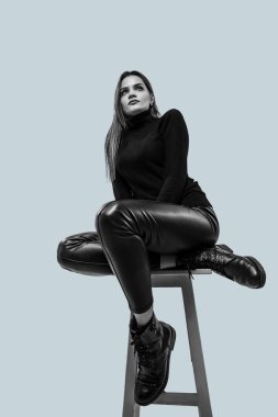 Gri arka planda izole edilmiş güzel bir kızın siyah beyaz portresi..