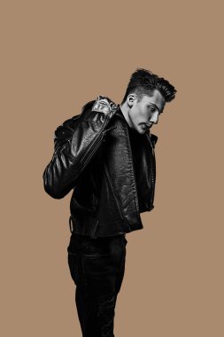 Kafkasyalı genç adam ışık stüdyosunun arka planında yalnız poz veriyor. Yan görünüm