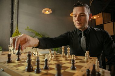 Ciddi satranç oyuncusu evde oturup tek başına satranç oynuyor..