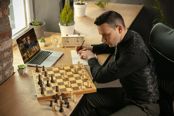 Young Caucasian man chess player playing chess online with his student.
