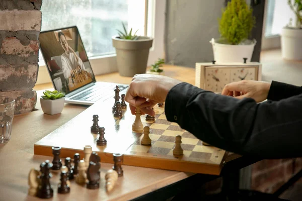 Крупным планом мужские руки играют в шахматы онлайн с молодой женщиной. — стоковое фото
