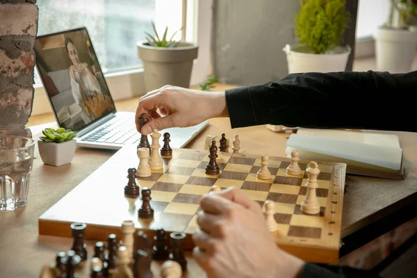 Крупным планом мужские руки играют в шахматы онлайн с молодой женщиной. — стоковое фото