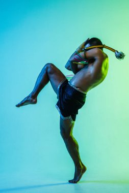 Genç adam Thai boksör eğitimi mavi arka planda neon ışığı altında.