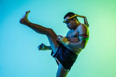 Genç adam Thai boksör eğitimi mavi arka planda neon ışığı altında.