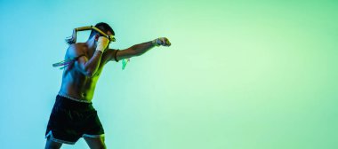 Genç adam Thai boksör eğitimi mavi arka planda neon ışığı altında.